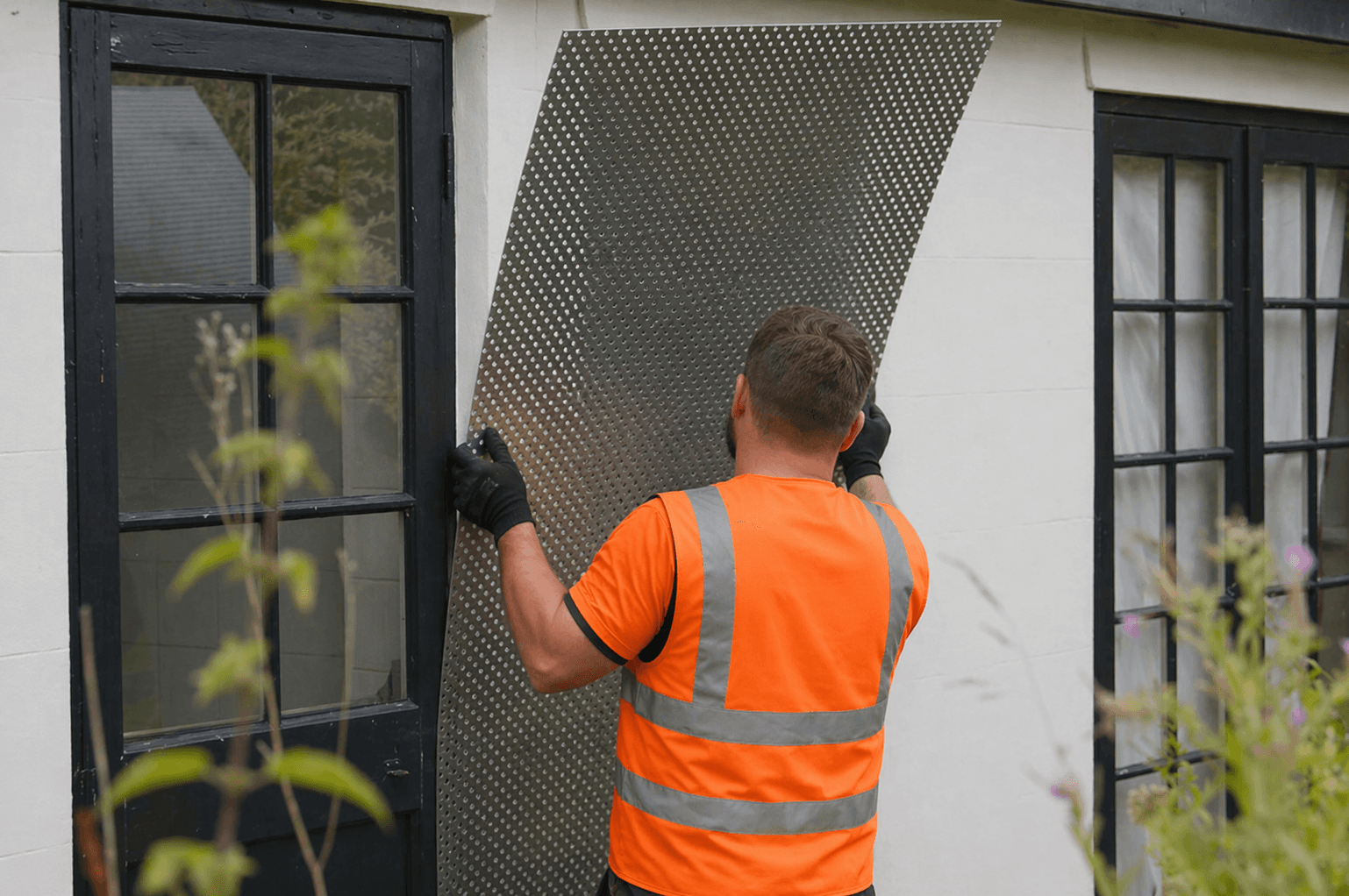 Worker installing steel shuttering on a vacant property